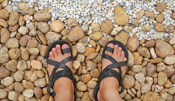 Looking down at the feet on a gravel stones decorate in the garden