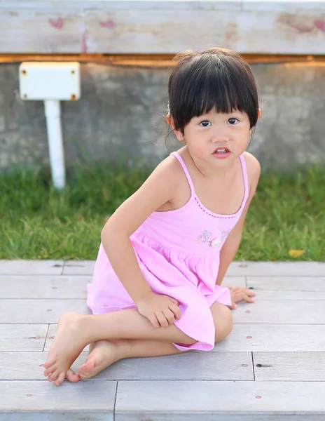 Retrato de menina com emoção natural sorrindo no jardim público à beira-mar — Fotografia de Stock