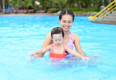 Açık Yüzme havuzunda oynayan annesi ile sevimli küçük kız