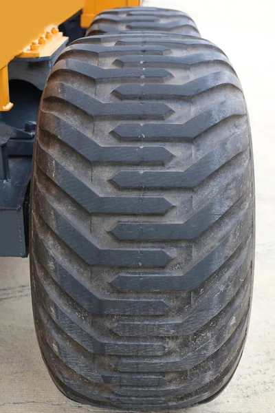 Yellow tractor with a big wheel. Wheel with a large tread — Stock Photo, Image