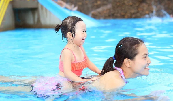Bella bambina con sua madre che gioca in piscina all'aperto — Foto Stock