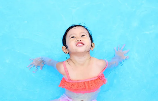 Linda niña jugando en la piscina al aire libre — Foto de Stock