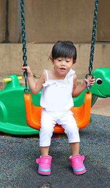 Şirin çocuk kız eğlence Bahçesi bir salıncak üzerinde