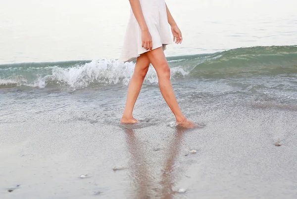 Mujer joven en vestido blanco caminando sola en la playa — Foto de Stock