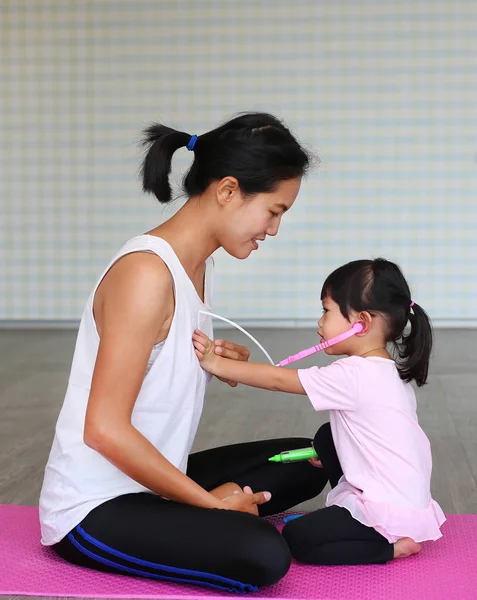 Mother and daughter playing doctor with stethoscope