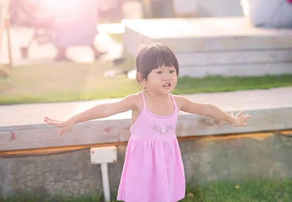 Retrato de menina com emoção natural sorrindo no jardim público à beira-mar — Fotografia de Stock