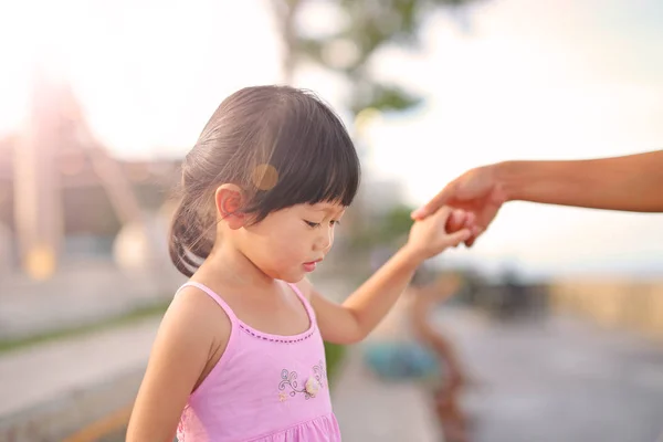 Potret gadis kecil berjalan dengan ibu Memegang tangan seseorang di pantai, Happy keluarga . — Stok Foto