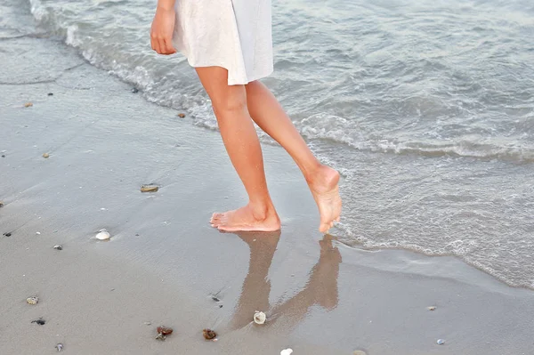 Mujer joven en vestido blanco caminando sola en la playa — Foto de Stock