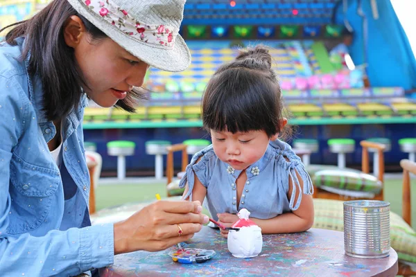 Madre y niña divirtiéndose para pintar en la muñeca de estuco — Foto de Stock