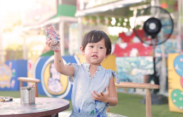 Pintura infantil, Retrato niña divirtiéndose para pintar en estuco muñeca — Foto de Stock