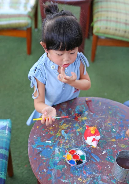 Pintura infantil, Retrato niña divirtiéndose para pintar en estuco muñeca — Foto de Stock