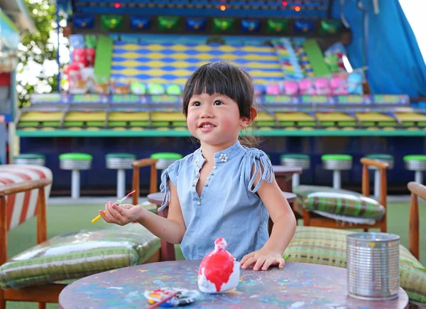 Pintura infantil, Retrato niña divirtiéndose para pintar en estuco muñeca — Foto de Stock