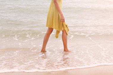 Yalnız kumsalda yürüyen genç kadın