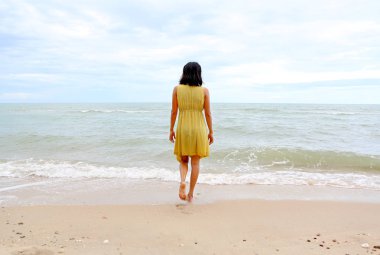 Genç kadın rahat Sahilde yürüyüş gitmek düz denize