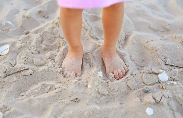 Miúdo menina jogando areia na praia — Fotografia de Stock
