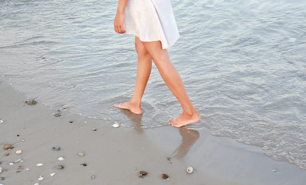 Mujer joven en vestido blanco caminando sola en la playa —  Fotos de Stock