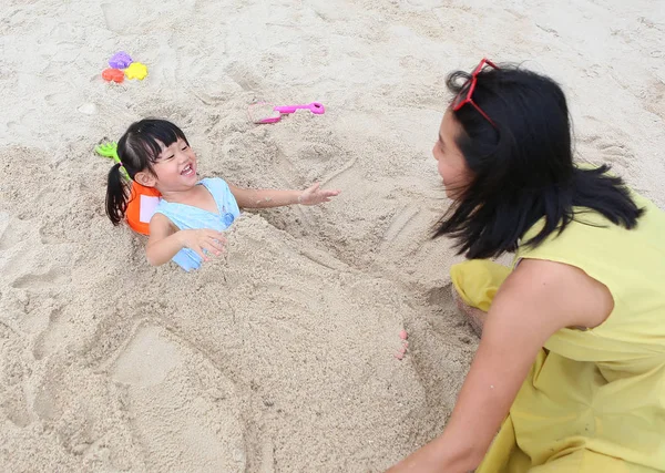 Feliz familia amorosa. Madre y su hija niña jugando a la arena en la playa —  Fotos de Stock