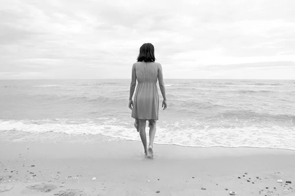 Mujer joven caminando sola en la playa — Foto de Stock