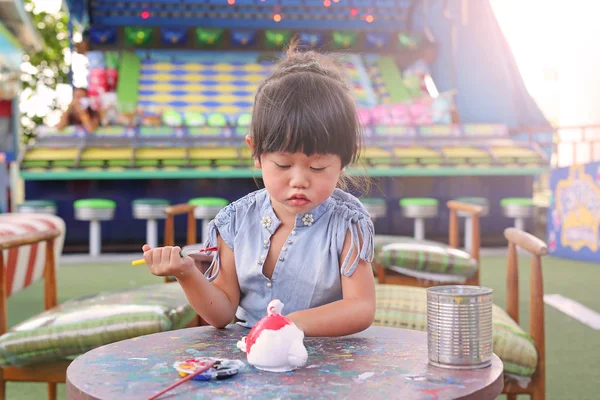 Peinture d'enfant, Portrait petite fille s'amusant à peindre sur poupée en stuc — Photo