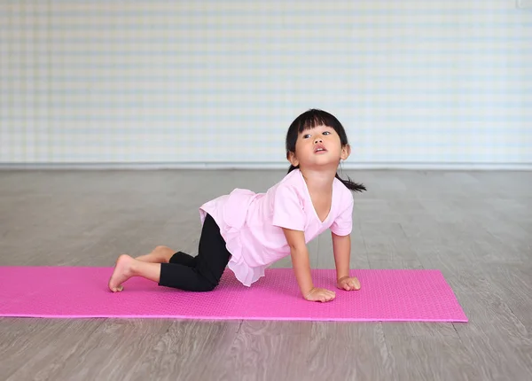 Kleines Mädchen praktiziert Yoga oder Sport — Stockfoto