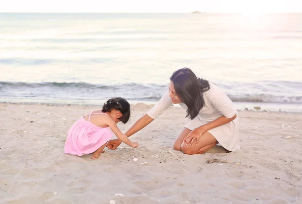 Ευτυχισμένη οικογένεια στην αγάπη. Μητέρα και κόρη της παιδί κορίτσι παίζει άμμο στην παραλία — Φωτογραφία Αρχείου