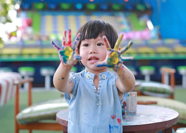 Linda niña con las manos pintadas, enfoque selectivo en la mano — Foto de Stock