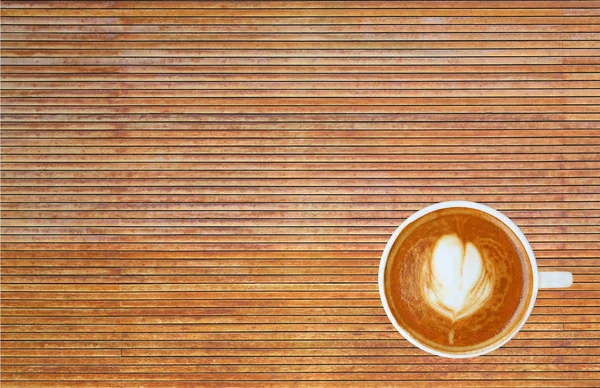 Vue du dessus d'un café avec motif coeur dans une tasse blanche sur fond bois, latte art — Photo