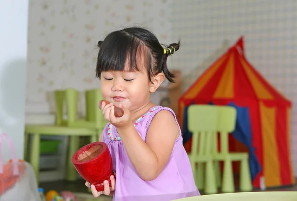 Asiática niña jugar para hacer la ensalada de papaya verde o "somtam" en la sala de estar — Foto de Stock