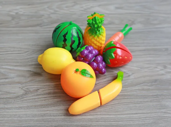 木材の背景、子供たちのおもちゃのプラスチックの果物 — ストック写真