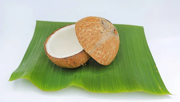 Noix de coco avec coquille sur feuille de banane isolée sur fond blanc — Photo