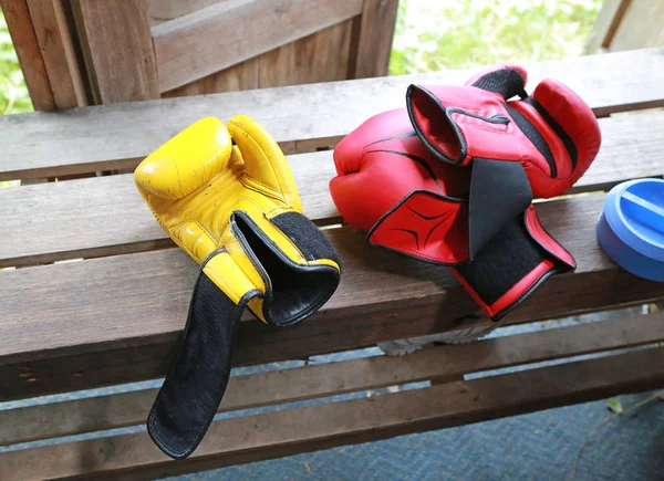 Rote und gelbe Boxhandschuhe auf Holz. — Stockfoto