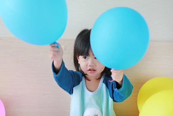 Söt liten asiatisk flicka spelar på säng med ballong. — Stockfoto