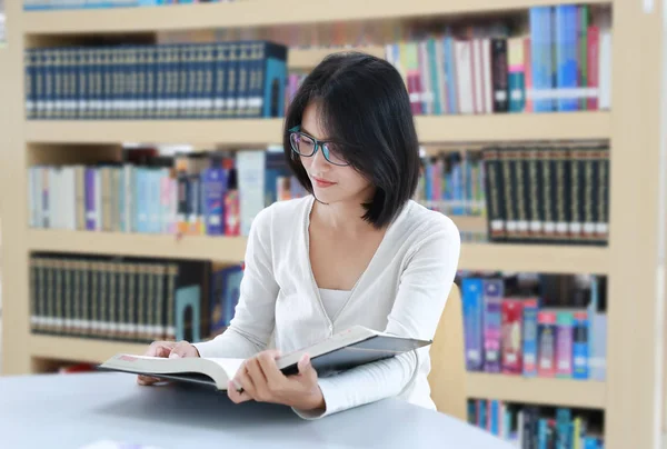 Azjatycki student czytania książki w bibliotece — Zdjęcie stockowe