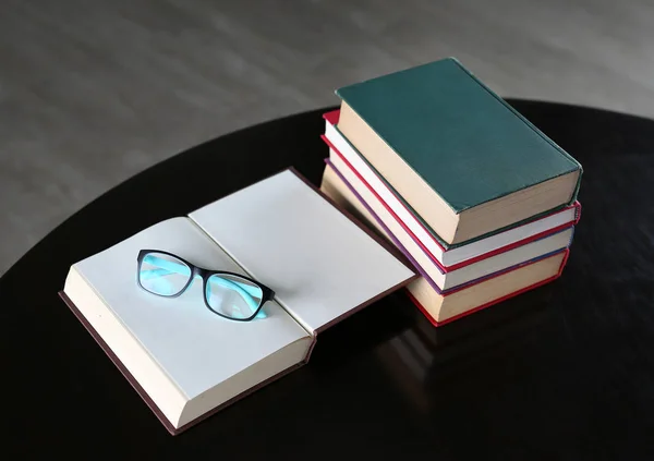 Открытая книга, книги в твердом переплете и очки на деревянном столе. Образование . — стоковое фото