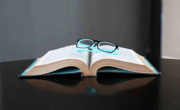 Открытая книга, книги в твердом переплете и очки на деревянном столе. Образование . — стоковое фото