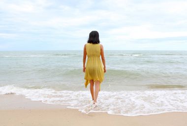 Genç kadın rahat Sahilde yürüyüş gitmek düz denize