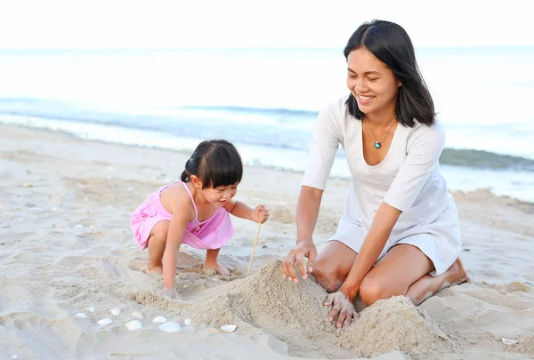 Mutlu sevgi dolu aile. Anne ve kızı çocuk kızının oynarken sahilde kum — Stok fotoğraf