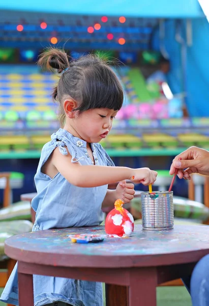 Peinture d'enfant, Portrait petite fille s'amusant à peindre sur poupée en stuc — Photo