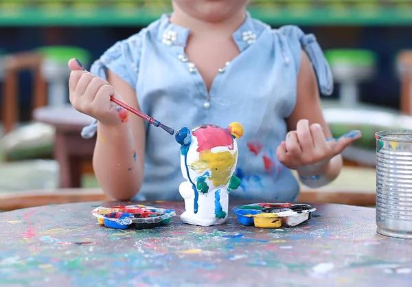 Kindermalerei, Portrait kleines Mädchen hat Spaß beim Malen auf Stuckpuppe — Stockfoto