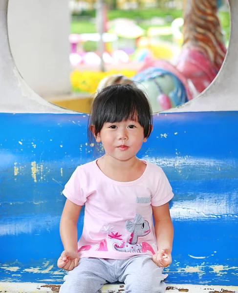 Feliz niña adorable sonriendo en un carruaje en un carrusel — Foto de Stock