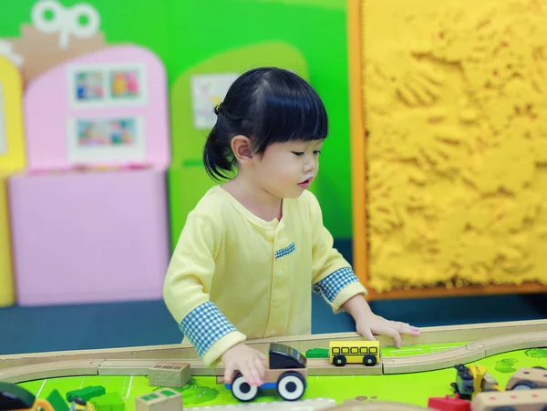 Petite fille jouant avec des voitures jouets — Photo