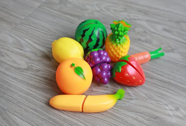 Kunststoff-Früchte auf Holz-Hintergrund, Kinderspielzeug — Stockfoto