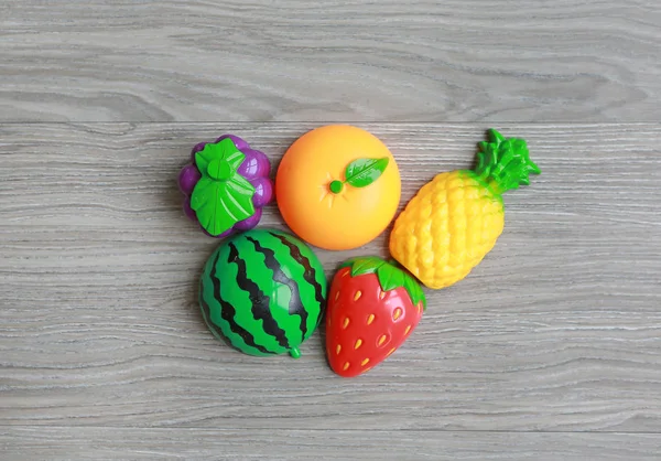 Plastic fruits on wood background, Children\'s toy