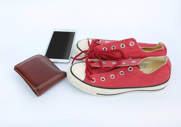 Paar nieuwe rode sneakers met slimme telefoon en portemonnee op witte achtergrond — Stockfoto