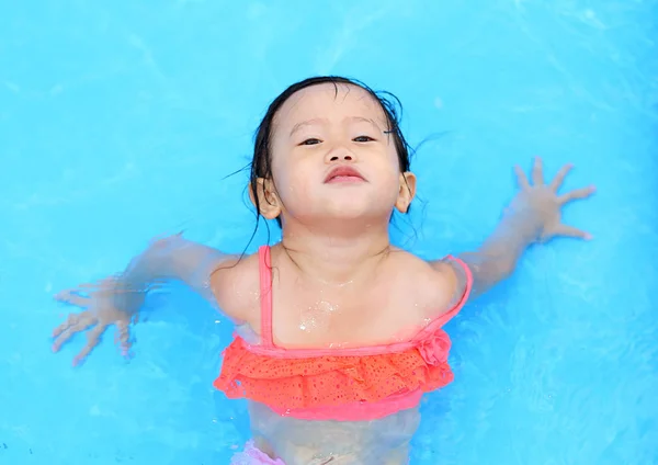 Досить маленька дівчинка грає в басейні на відкритому повітрі — стокове фото