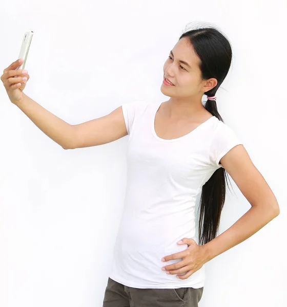 Nahaufnahme asiatisches Mädchen, das Fotos von sich durch Handy auf weißem Hintergrund macht — Stockfoto