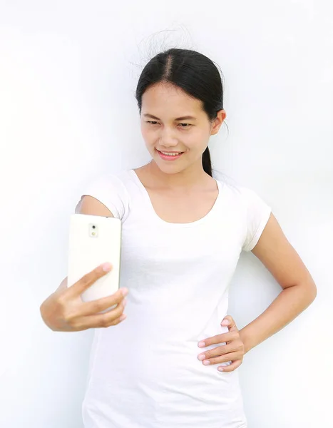 Närbild av Asiatisk tjej att ta bilder av sig själv genom mobilen på vit bakgrund — Stockfoto