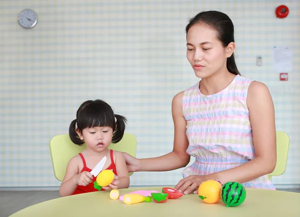 Aziatische kind meisje en moeder spelen kunststof fruit op de kamer Kid — Stockfoto