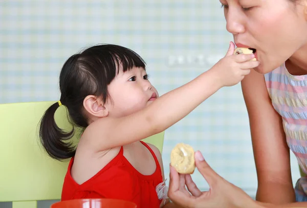 Dziewczyna azjatyckich dziecko i matka jedzenie gotowane jajko w salonie — Zdjęcie stockowe