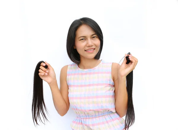 Asian woman donating her hair to cancer patients - holding her former hair after a haircut, generously donating her long hair for making wigs for cancer patients who lost their hair — Stock Photo, Image